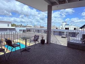 a balcony with a table and chairs and a view of a parking lot at Morrinsville Motel in Morrinsville