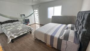 a bedroom with a bed and a chair and a window at Hacienda Dalas Alojamiento Campestre in Villavicencio +12 photos