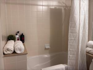 a bathroom with a shower and a tub with towels at A lovely one bed room with Sunset Views in Toronto +21 photos
