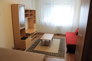 un soggiorno con divano rosso e tavolo di Louis Apartment a Budapest