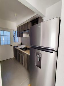 a stainless steel refrigerator in a kitchen at Fraccionamiento Puerta al Sol Acapulco in General Juan N Alvarez International Airport
