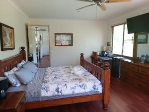 a bedroom with a large bed with a wooden frame at Quand0ng Valley Inn The Waterfall Room in Minynon +63 photos