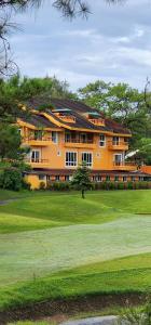 バギオにあるLuxury Residence #4 - Atticのゴルフ場内の大きなオレンジ色の建物