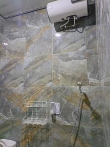 a bathroom with a stone wall and a toilet at Athallah Homestay Syariah in Lampung