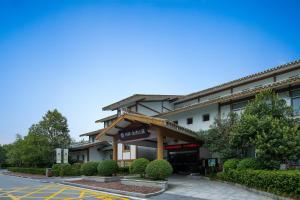 a hotel building with a sign on the front of it at Floral design Longhu Mountain Residence in Caijia