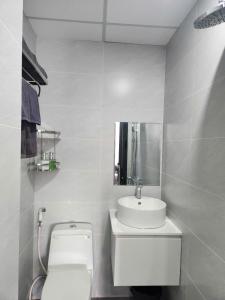 a white bathroom with a toilet and a sink at Eco BMT LUXURY HOTEL in Buon Ma Thuot +14 photos