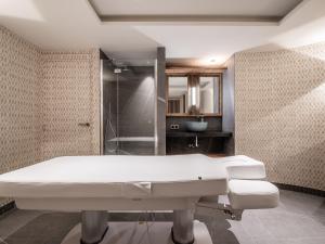 a bathroom with a white bath tub and a shower at Chalet Penthouse Luxe à Méribel - Concierge, Spa, Parking - FR-1-613-41 in Méribel +26 photos