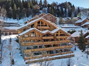 a large wooden building in the snow at Duplex 4 chambres à Méribel, près du centre et des pistes, avec services de conciergerie - FR-1-613-47 in Les Allues