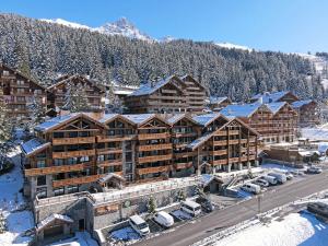 eine Luftansicht einer Lodge im Schnee in der Unterkunft Duplex Spacieux au Rond-Point des Pistes avec Parking, Balcon et Services Inclus - FR-1-613-93 in Les Allues