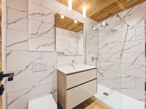 a bathroom with a sink and marble walls at Appartement 8 pers rénové, 2 ch, accepte animaux, garage - La Clusaz - FR-1-818-21 in La Clusaz +8 photos
