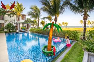 a child playing in a pool at a resort at The Five Stars Villa 8 Bedrooms Beachfront in Danang