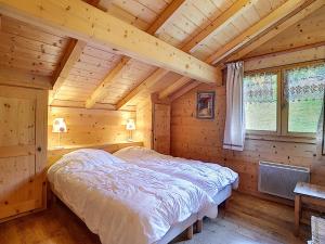 a bedroom with a bed in a log cabin at Chalet haut de gamme 8 pers à La Clusaz avec Wifi et parking - FR-1-818-74 in La Clusaz
