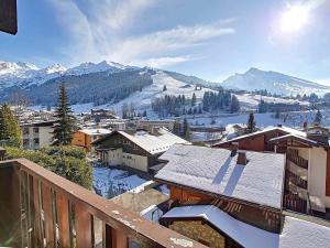 a view of a town with snow covered roofs at Appartement cosy 4/6 pers. avec balcon sud et wifi à La Clusaz - FR-1-818-79 in La Clusaz +4 photos