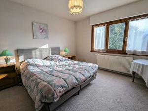 a bedroom with a bed and a table and windows at Maison à Gérardmer avec vue sur montagnes, garage et jardin - FR-1-589-776 in Gérardmer