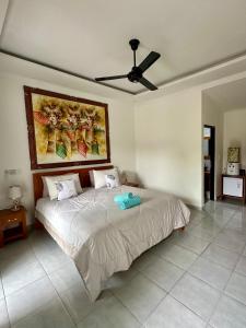 a bedroom with a bed with a ceiling fan at Wonder Dive Bali Tulamben Villa's in Tulamben
