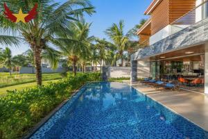 an external view of a house with a swimming pool at The Five Stars Villa 8 Bedrooms Beachfront in Danang