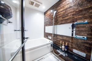a bathroom with a shower and a brick wall at Hotel Naranohamori in Nara +70 photos