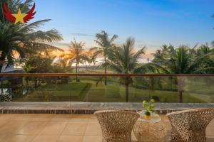 a balcony with a view of the palm trees at The Five Stars Villa 8 Bedrooms Beachfront in Danang +78 photos