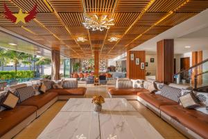 a living room with leather couches and a chandelier at The Five Stars Villa 8 Bedrooms Beachfront in Danang