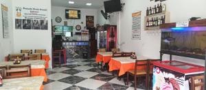 a restaurant with tables and chairs and a fish tank at Pousada Praia Grande Solemar in Praia Grande