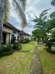 a yard of a house with trees and grass at Wonder Dive Bali Tulamben Villa's in Tulamben