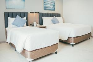Postel nebo postele na pokoji v ubytování NS Royal Hotel