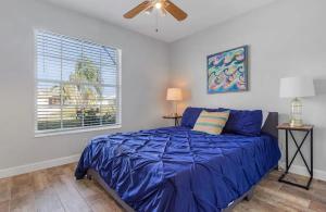 Un dormitorio con una cama con edredón azul y una ventana. en Luxury 6 Bedroom Vacation Home with Private Pool, en Cabo Coral 45 fotos más