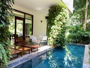 a house with a swimming pool next to a house at FLAMIGO Đại Lải - Villa Tự Doanh in Phúc Yên