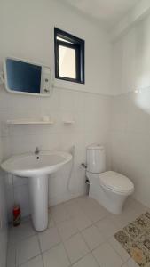 a white bathroom with a sink and a toilet at Relax Home in Sri Jayewardenepura Kotte +10 photos