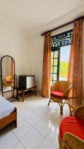 a bedroom with a bed and a tv and a window at Relax Home in Sri Jayewardenepura Kotte