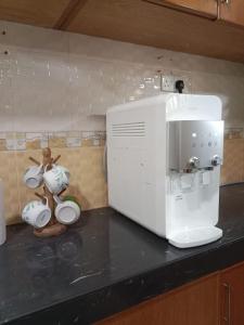 a kitchen counter with a coffee maker and a microwave at 6 bedroom Villa Medina Bungalow at Pantai Bagan Lalang in Tanjong Sepat
