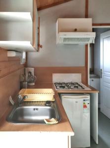 una cocina con fregadero y estufa en Chalet charmant à Saint-Jean-du-Gard, en Saint-Jean-du-Gard