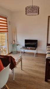 a living room with a couch and a tv at Cabaña Mediterranea ideal pareja con lindas vistas in Quintero