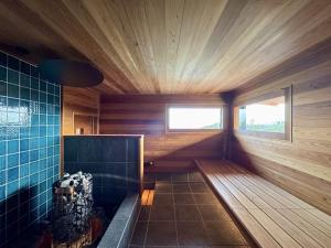 a room with a sauna with wooden walls and a window at Gardenvilla Shirahama in Shimoda