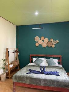 a bedroom with a bed with a blue wall at Khao Sok Green Mountain View in Khao Sok National Park