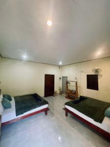 a bedroom with two beds and a tv on the wall at Khao Sok Green Mountain View in Khao Sok National Park