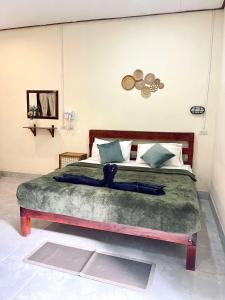a bedroom with a large bed with a green blanket at Khao Sok Green Mountain View in Khao Sok National Park