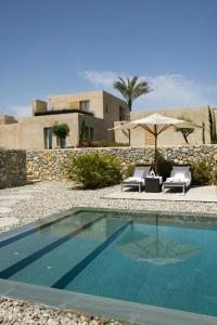a swimming pool with two chairs and an umbrella at Son Gener Hotel Spa in Son Servera