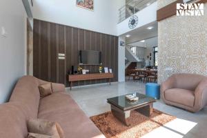 Una sala de estar con un sofá y un televisor. en Daffodil Villa by VEO - Part of StayVista, en Karjat
