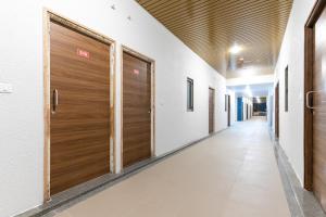 an empty corridor with wooden doors in a building at Hotel O C3 Celebration City Centre in Bodakdev