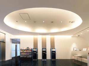 a lobby with three soda machines in a building at Sotetsu Fresa Inn Shimbashi-Karasumoriguchi in Tokyo