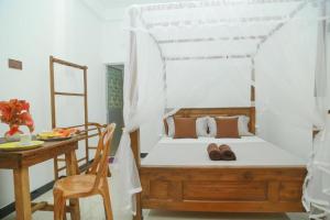 a bedroom with a bed and a table with a table sidx sidx at Vale Casa Family Guest House in Mirissa