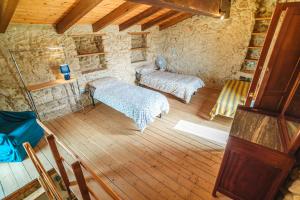 1 Schlafzimmer mit 2 Betten in einem Zimmer mit Holzböden in der Unterkunft Stonehouse apartments in Forcella