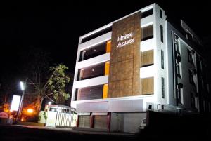 AnkleshwarHotel New Apex的晚上，一栋建筑的侧面挂着招牌