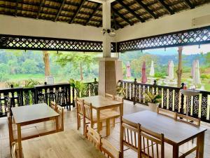 a restaurant with tables and chairs on a balcony at AsiaCamp Taman Negara Resort in Kuala Tahan