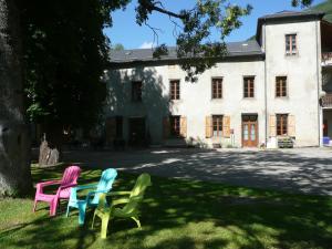 three chairs sitting in the grass in front of a building at Gite d'Etape Ascou La Forge in Ascou