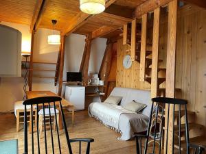 una camera da letto con un letto, un tavolo e delle sedie di Chalet montagnard avec balcon, proche piste et centre - FR-1-814-77 a Besse-et-Saint-Anastaise
