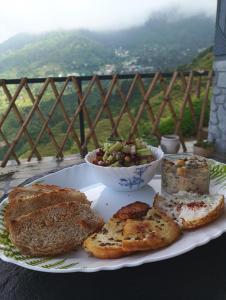 a plate of food with bread and a bowl of fruit at Paarli Dhara,Bir in Bīr