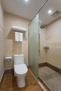 a bathroom with a toilet and a glass shower at Floral design Longhu Mountain Residence in Caijia
