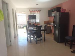 eine Küche mit Tisch, Stühlen und Kühlschrank in der Unterkunft ABY Sky House in Mérida